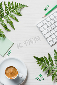 咖啡杯, 蕨类树叶, 文具和电脑键盘在桌上的高视图 