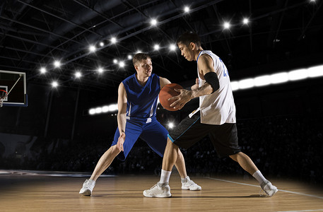 行动在健身房中的两个篮球运动员。