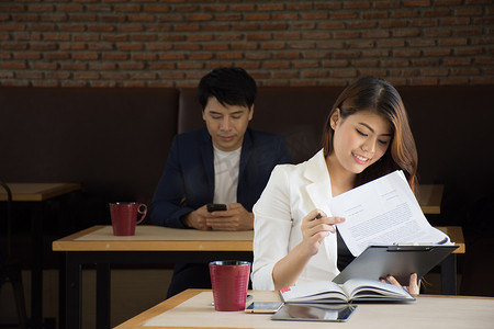 汇报策划摄影照片_年轻妇女汇报他们的商业意图，并且乐于在一家咖啡店.