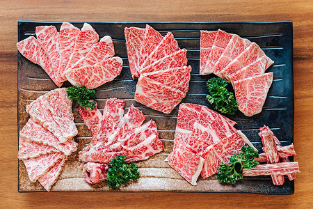 高级稀有切片的顶视图 Wagyu A5 牛肉的许多部分，在石板上具有高大理石纹理，为 Yakiniku（烤肉）服务).