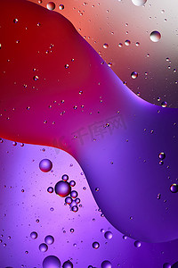 红色质感摄影照片_美丽的紫色和红色从混合水和油泡中抽象出质感