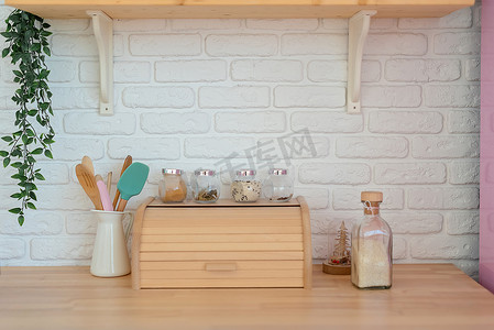 现代化厨房，白色墙壁，木制台面，面包篮，架子和粉色冰箱。生活方式厨房装饰