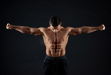 强壮的运动员演示手臂肌肉的 Frontview.