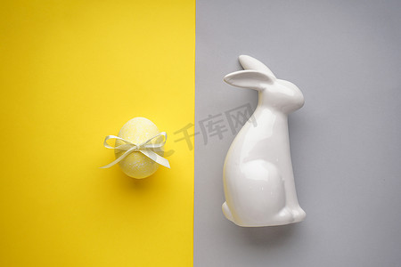 复活节兔子陶瓷，黄色复活节彩带彩蛋，黄灰色背景，平铺.