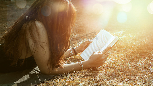 女人在公园里放松阅读。假日 睡眠休息在阅读。年轻女性在假期里放松、睡觉、看书。性质， 户外， 假期， 教育， 读书， 书， 写笔记， 日记.