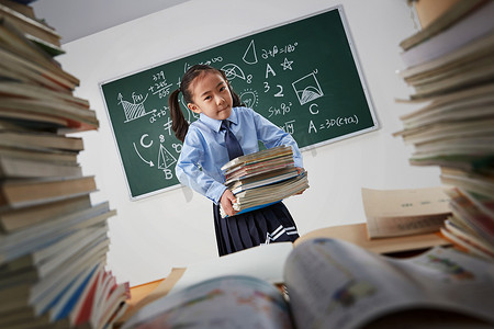 搬书摄影照片_搬着沉重课本的小学女生