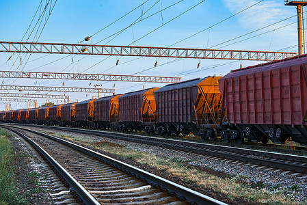 轨道车摄影照片_美丽的日落和多彩的天空中的铁路基础设施, 干货运, 运输和工业概念的轨道车