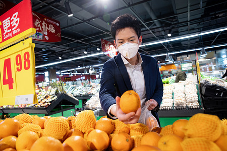 戴口罩的青年男人在超市购买水果