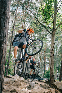 年轻的试验骑自行车在美丽的森林的后轮骑车