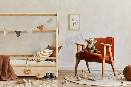 用木床、红色扶手椅、毛绒玩具、木制玩具和悬挂装饰品装饰舒适舒适的儿童房间的时尚构图。中间的墙，地板上的地毯。复制空间。模板. 