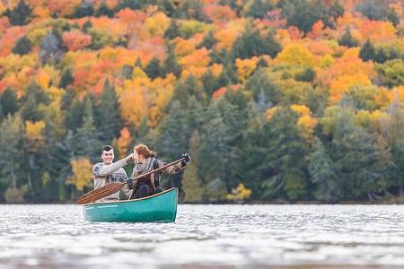 幸福的夫妇在加拿大的一个湖中划独木舟