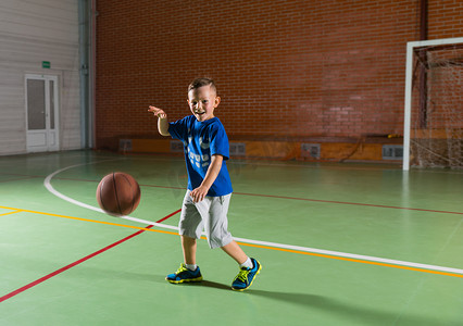 笑年轻男孩在打篮球
