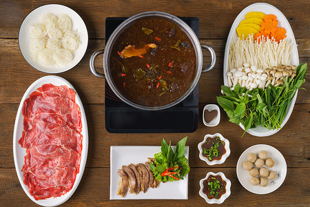 泰式炖牛肉火锅，中式浓汤，鲜肉炖牛肉球，木桌蔬菜配餐的食品背景