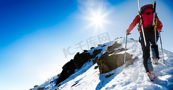 实现自我摄影照片_滑雪登山者沿着陡峭的白雪皑皑的山脊走
