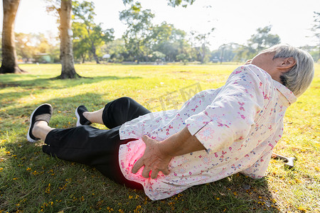 妇女维权摄影照片_亚洲老年人由于独自走路、滑倒、摔倒在地板上、老年妇女躺在地上、跌倒后触碰疼痛的臀部、腰部或扣子而发生意外