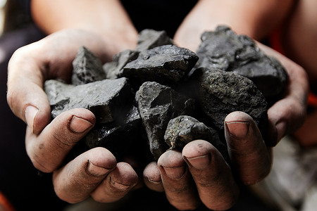 煤矿矿工在人手中的煤炭背景。煤炭开采或能源、环保。工业煤。火山岩.