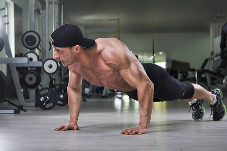 帅强大健壮的男人表演俯卧撑在健身房里。强与完美的背部、 肩膀、 肱二头肌、 肱三头肌和胸部健美.