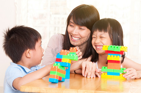 亚洲妇女和儿童玩积木