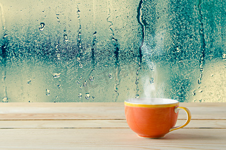 与天然水的咖啡杯滴眼液对玻璃窗口背景