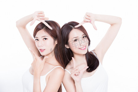 两个美容护肤妇女在白色背景下做框架手势