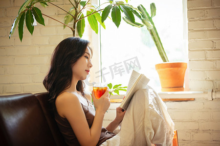 年轻女人在家喝茶看书