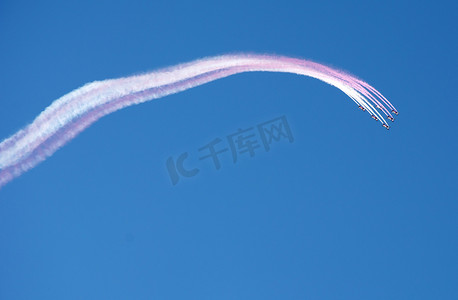 特技飞行队编队飞行，在蓝天上留下白色粉红色烟雾痕迹