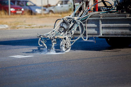 Teamwork: Pavement Asphalt Road Marking Paint and Striping with Thermoplastic Spray Applicator Machine during highway construction works