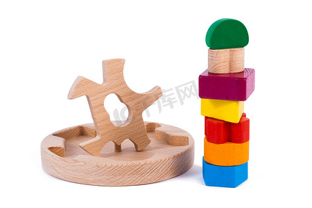 分拣中摄影照片_一个木制玩具儿童分拣器的照片，其木制细节呈几何形状（矩形、正方形、圆形、三角形），在白色孤立的背景中以不同的颜色出现