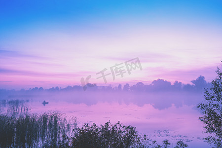 湖面上神奇的日出清晨朦胧,乡村风光,荒野,神秘的感觉.平静的湖水在神奇的光芒中