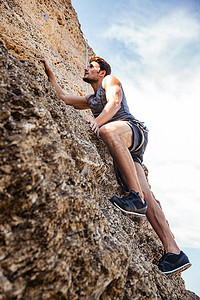 壁摄影照片_年轻男子攀爬自然岩壁