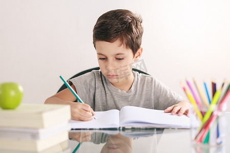 一个男孩做他的作业和在家学习的坦率肖像