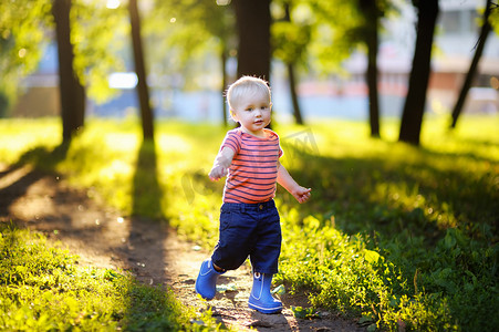 蹒跚学步的小男孩在公园跑步 