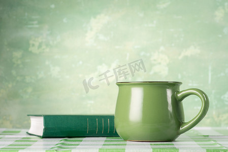 绿色的书和杯子在桌子上
