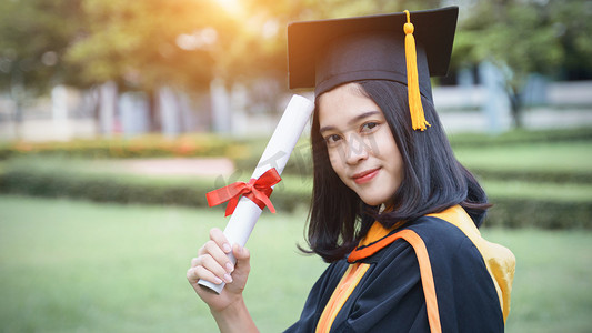 年轻的亚洲女大学毕业生在毕业典礼上获得大学学位证书后，与朋友一起欢庆和快乐。恭喜毕业典礼.