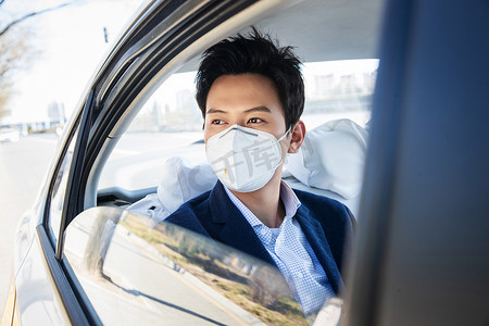 上下班摄影照片_年轻男人戴口罩乘坐汽车
