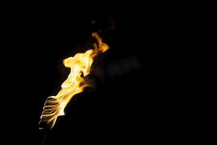 火把的火焰在黑暗中在黑色的背景上，只有火焰是看得见的