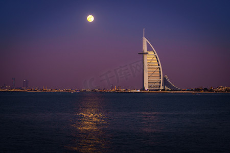迪拜明珠摄影照片_迪拜, 阿联酋, 2016年12月13日: 满月正在上升的迪拜塔阿拉伯-世界上唯一的7星级豪华酒店