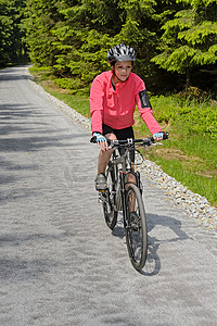 径摄影照片_在阳光明媚的单车径上女人骑自行车