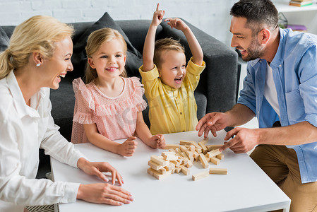 积木摄影照片_在家玩木制积木的快乐家庭 