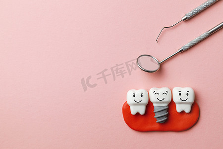 健康的白色牙齿和植入物微笑在粉红色的背景和牙医工具镜子, 钩子。复制文本的空间.