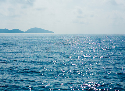 蓝色的海面，闪耀的波浪，背景上的群山，美丽的海景 