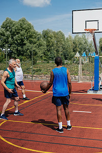 天天半价摄影照片_多种族老年人在操场上打篮球在夏天天