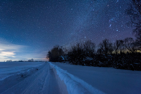 星罗黑的天空和雪天的道路在喀尔巴泰山脉的夜晚在冬天