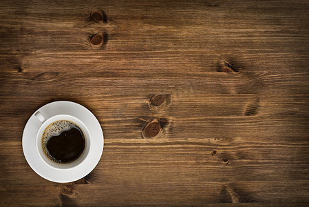 木制桌子背景图上的咖啡杯顶部视图