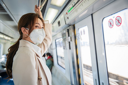 戴口罩的年轻女人乘坐地铁