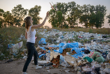 扔垃圾摄影照片_扔垃圾的年轻女孩.