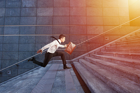 在奔跑摄影照片_商人在现代化的楼梯上奔跑得飞快