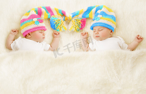 双胞胎婴儿睡在帽子里，刚出生的孩子睡着了，新出生