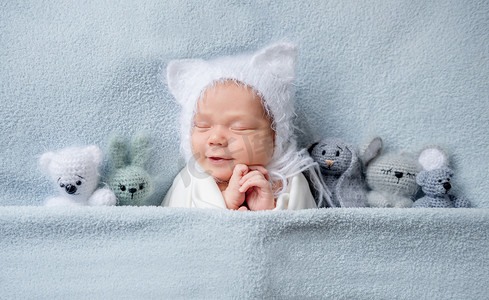 婴儿在帽子与耳朵睡觉与玩具