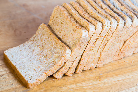 在一张小木桌上切面包的面包行.